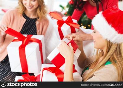 christmas, x-mas, happiness, winter and people concept - three women in santa helper hats holding many gift boxes