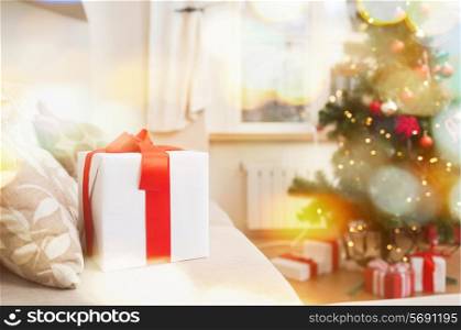 christmas, x-mas, holidays, winter and happiness concept - gift box on coach at home