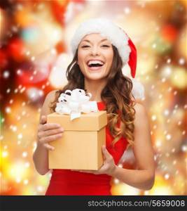 christmas, x-mas, new year, happiness concept - smiling woman in santa helper hat with gift box
