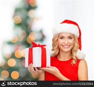 christmas, x-mas, new year, winter, happiness concept - smiling woman in santa helper hat with gift box