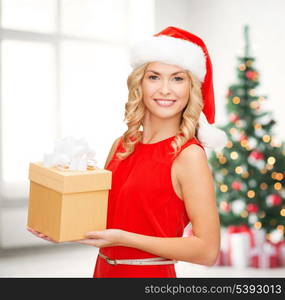 christmas, x-mas, new year, winter, happiness concept - smiling woman in santa helper hat with gift box