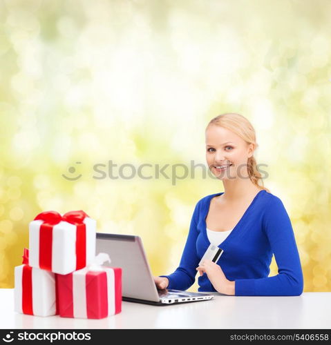 christmas, x-mas, online shopping concept - smiling woman with gift boxes, laptop computer and credit card