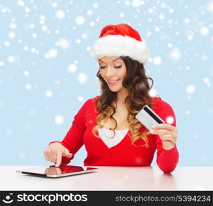 christmas, x-mas, online shopping concept - woman in santa helper hat with gift box, tablet pc computer and credit card