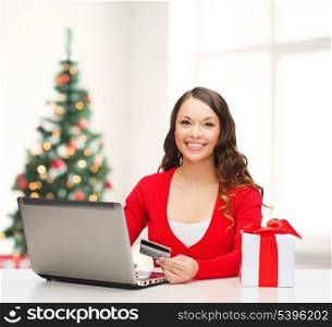 christmas, x-mas, online shopping concept - woman with gift box, laptop computer and credit card