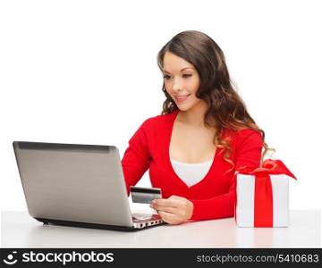 christmas, x-mas, online shopping concept - woman with gift box, laptop computer and credit card