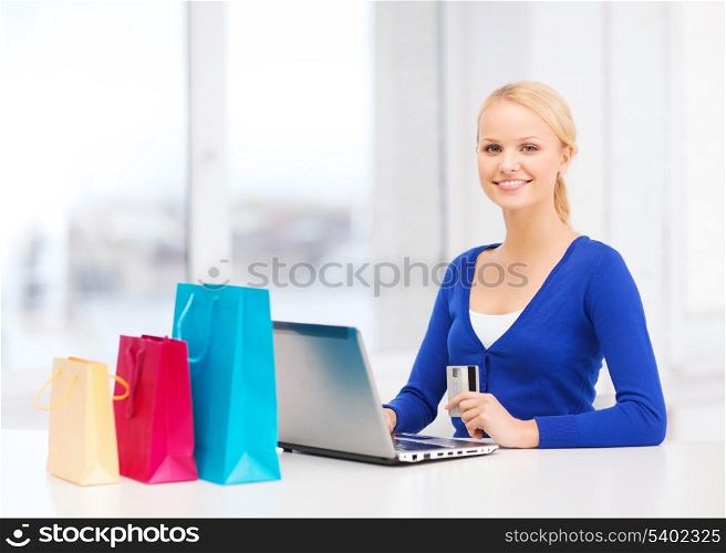 christmas, x-mas, online shopping concept - woman with shopping bags, laptop and credit card