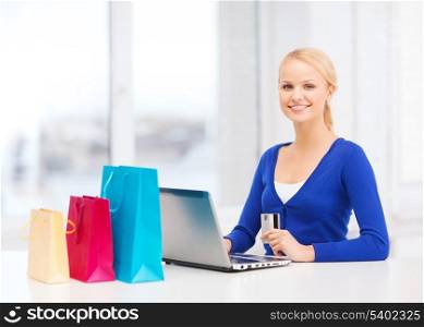 christmas, x-mas, online shopping concept - woman with shopping bags, laptop and credit card