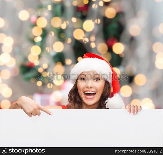 christmas, x-mas, people, advertisement and sale concept - happy woman in santa helper hat with blank white board over tree lights background