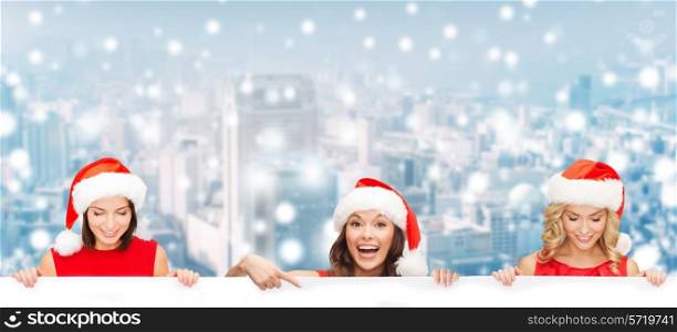 christmas, x-mas, people, advertisement and sale concept - happy women in santa helper hat with blank white board over snowy city background