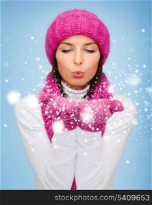 christmas, x-mas, people, happiness concept - happy woman in winter clothes blowing on palms