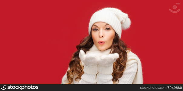 christmas, x-mas, people, happiness concept - happy woman in winter clothes blowing on palms