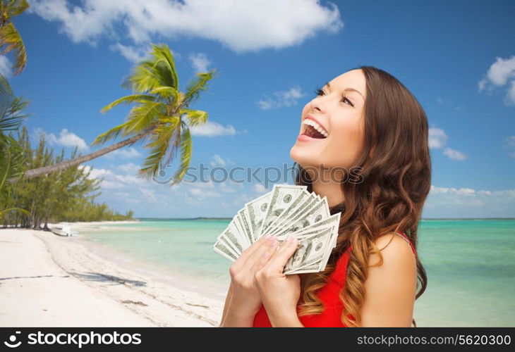 christmas, x-mas, sale, banking and travel concept - smiling woman in red dress with us dollar money over tropical beach background