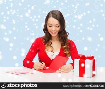 christmas, x-mas, valentine&#39;s day, celebration concept - smiling woman in red clothes with gift box and postcard