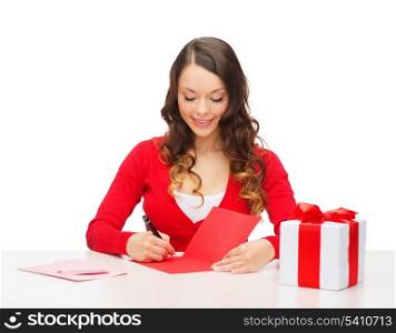christmas, x-mas, valentine&#39;s day, celebration concept - smiling woman in red clothes with gift box and postcard