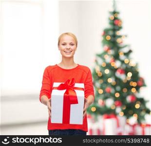 christmas, x-mas, valentine&#39;s day, celebration concept - smiling woman in red sweater with gift box