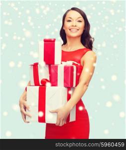 christmas, x-mas, valentine&amp;#39;s day, celebration concept - smiling woman in red dress with many gift boxes