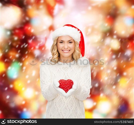 christmas, x-mas, winter, charity, love, happiness concept - smiling woman in santa helper hat with red heart