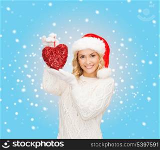christmas, x-mas, winter, charity, love, happiness concept - smiling woman in santa helper hat with red heart