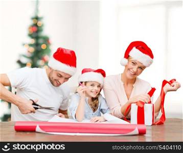 christmas, x-mas, winter,family, happiness and people concept - smiling family in santa helper hats with gift box
