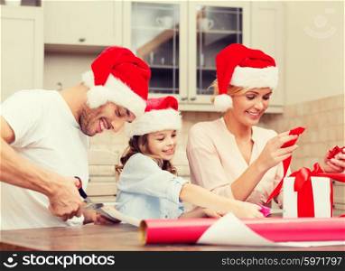 christmas, x-mas, winter,family, happiness and people concept - smiling family in santa helper hats with gift box