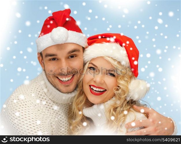 christmas, x-mas, winter, happiness concept - family couple in sweaters and santa&#39;s hats