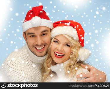 christmas, x-mas, winter, happiness concept - family couple in sweaters and santa&#39;s hats