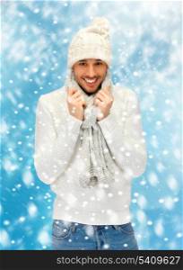 christmas, x-mas, winter, happiness concept - handsome man in warm sweater, hat and scarf