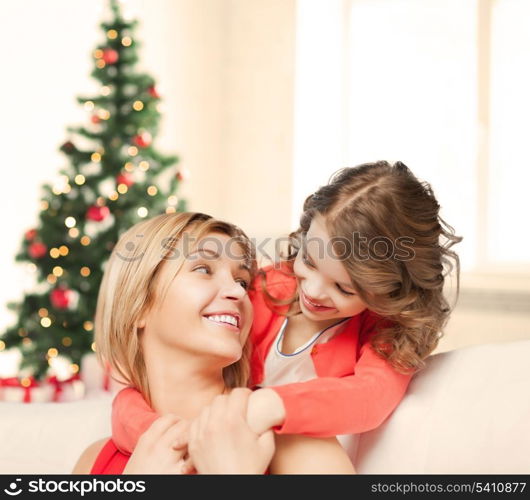 christmas, x-mas, winter, happiness concept - hugging mother and daughter