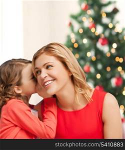christmas, x-mas, winter, happiness concept - mother and daughter whispering gossip