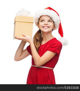 christmas, x-mas, winter, happiness concept - smiling girl in santa helper hat with gift box