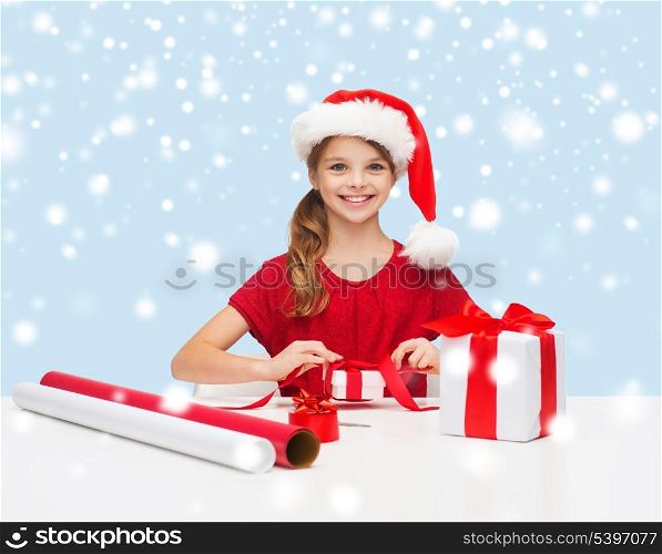 christmas, x-mas, winter, happiness concept - smiling girl in santa helper hat with gift box