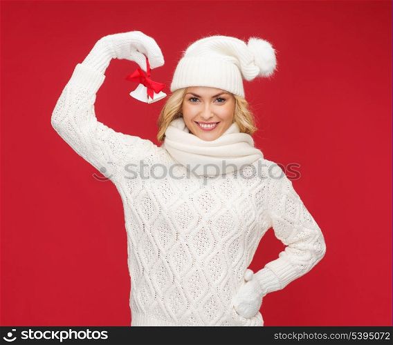 christmas, x-mas, winter, happiness concept - smiling woman in mittens and hat with jingle bells