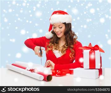 christmas, x-mas, winter, happiness concept - smiling woman in santa helper hat with gift box, wrapping paper and ribbon