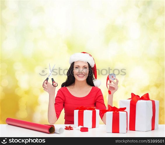 christmas, x-mas, winter, happiness concept - smiling woman in santa helper hat with many gift boxes
