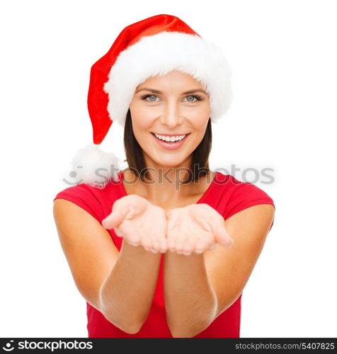 christmas, x-mas, winter, happiness concept - smiling woman in santa helper hat with something on palms