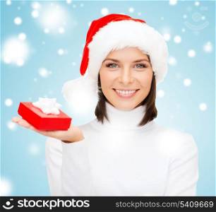 christmas, x-mas, winter, happiness concept - smiling woman in santa helper hat with small gift box