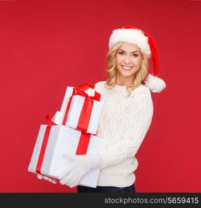 christmas, x-mas, winter, happiness concept - smiling woman in santa helper hat with many gift boxes