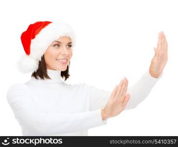 christmas, x-mas, winter, happiness concept - smiling woman in santa helper hat touching something