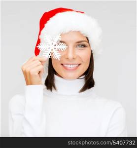 christmas, x-mas, winter, happiness concept - smiling woman in santa helper hat with big snowflake