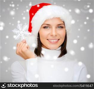christmas, x-mas, winter, happiness concept - smiling woman in santa helper hat with big snowflake