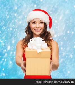 christmas, x-mas, winter, happiness concept - smiling woman in santa helper hat with gift box