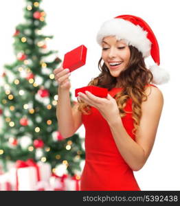 christmas, x-mas, winter, happiness concept - smiling woman in santa helper hat with gift box