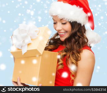 christmas, x-mas, winter, happiness concept - smiling woman in santa helper hat with gift box