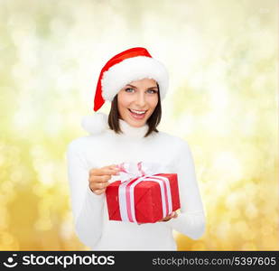 christmas, x-mas, winter, happiness concept - smiling woman in santa helper hat with gift box