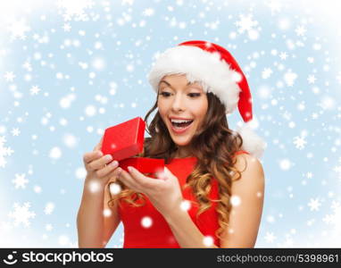 christmas, x-mas, winter, happiness concept - smiling woman in santa helper hat with gift box