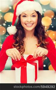 christmas, x-mas, winter, happiness concept - smiling woman in santa helper hat with gift box