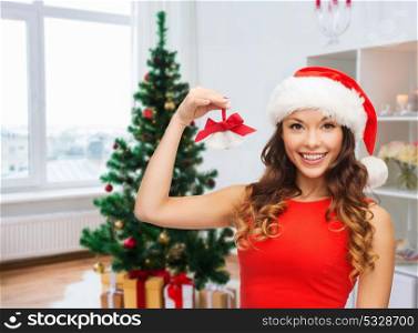 christmas, x-mas, winter, happiness concept - smiling woman in santa helper hat with jingle bells. woman in santa helper hat with jingle bells