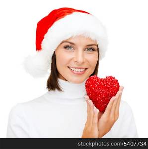christmas, x-mas, winter, happiness concept - smiling woman in santa helper hat with red heart