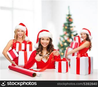 christmas, x-mas, winter, happiness concept - smiling women in santa helper hat with gift box