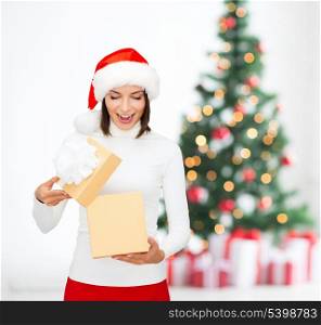 christmas, x-mas, winter, happiness concept - surprised woman in santa helper hat with gift box